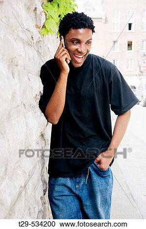 Young man talking on a cell phone. Montreal. Quebec. Canada. View Large Photo Image Stock Image - Young man talking on a cell phone. Montreal. Quebec. Canada.. Fotosearch