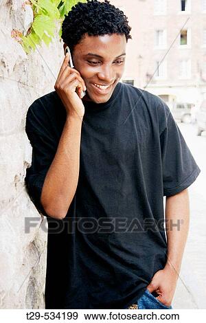 Young man talking on a cell phone. Montreal. Quebec. Canada. View Large Photo Image Stock Photo - Young man talking on a cell phone. Montreal. Quebec. Canada.. Fotosearch