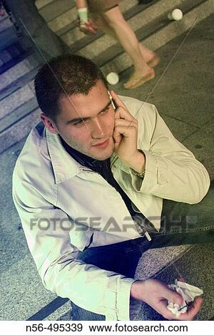 Stock Photo - Young man using cell phone. Fotosearch