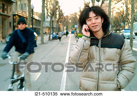 Stock Photography - Young man using cell phone. Fotosearch
