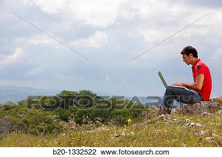 Stock Image - Young man using laptop computer, Murguia, Alava, Euskadi, Spain. Fotosearch