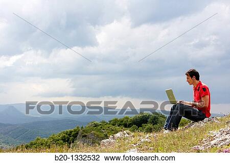 Young man using laptop computer, Murguia, Alava, Euskadi, Spain View Large Photo Image Stock Image - Young man using laptop computer, Murguia, Alava, Euskadi, Spain. Fotosearch