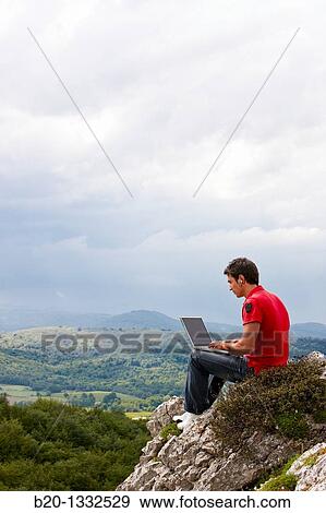 Young man using laptop computer, Murguia, Alava, Euskadi, Spain View Large Photo Image Stock Photo - Young man using laptop computer, Murguia, Alava, Euskadi, Spain. Fotosearch