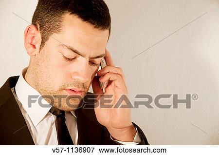 Stock Photo - Young man using mobile phone. Close view.. Fotosearch