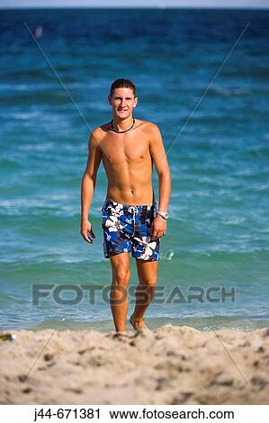 Young man walking at the beach, Hollywood, Florida, USA View Large Photo Image Stock Image - Young man walking at the beach, Hollywood, Florida, USA. Fotosearch