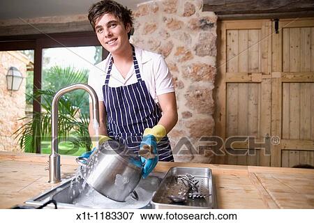 Stock Photo - Young man Washing dishes.. Fotosearch