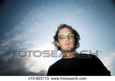 Stock Image - Young man wearing funny glasses.. Fotosearch
