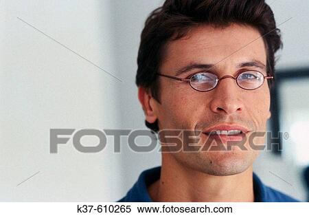 Young man wearing reading glasses View Large Photo Image Stock Photography - Young man wearing reading glasses. Fotosearch