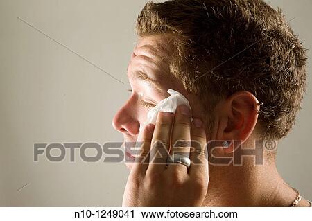 Young man wiping his face with a paper towel View Large Photo Image Stock Image - Young man wiping his face with a paper towel. Fotosearch