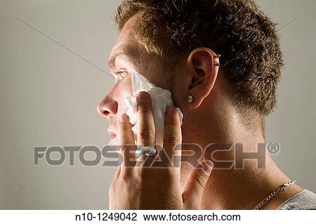 Young man wiping his face with a paper towel View Large Photo Image Stock Image - Young man wiping his face with a paper towel. Fotosearch