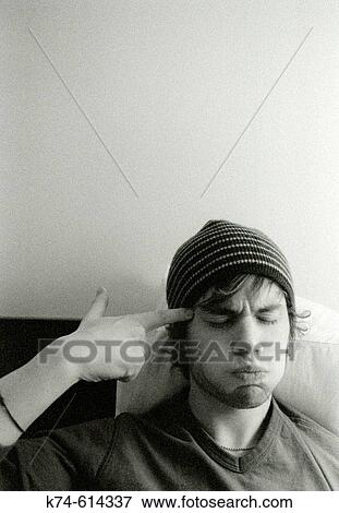 young man with finger pointing at his head, eyes closed View Large Photo Image Stock Photo - young man with finger pointing at his head, eyes closed. Fotosearch