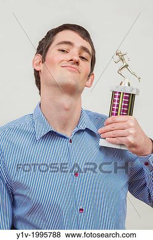 Stock Photo - Young man with his trophy.. Fotosearch