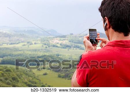 Young man with iPhone, Murguia, Alava, Euskadi, Spain View Large Photo Image Stock Photo - Young man with iPhone, Murguia, Alava, Euskadi, Spain. Fotosearch