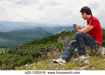 Young man with iPhone, Murguia, Alava, Euskadi, Spain View Large Photo Image Stock Photograph - Young man with iPhone, Murguia, Alava, Euskadi, Spain. Fotosearch