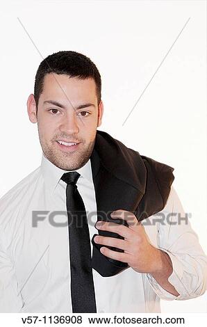 Stock Photo - Young man with jacket on his shoulder, smiling and looking at the camera.. Fotosearch