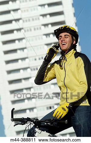 Young man with mobile phone on the bike. Valencia. Espaa View Large Photo Image Stock Image - Young man with mobile phone on the bike. Valencia. Espaa. Fotosearch