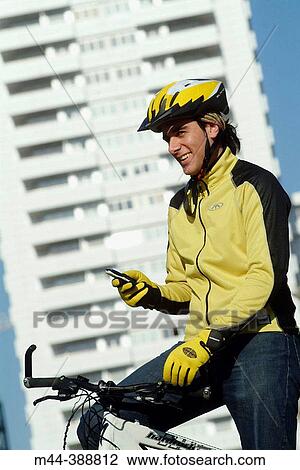 Young man with mobile phone on the bike. Valencia. Espaa View Large Photo Image Stock Image - Young man with mobile phone on the bike. Valencia. Espaa. Fotosearch