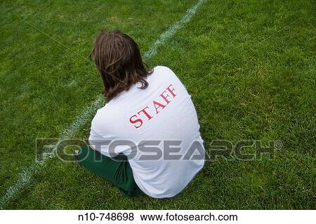 Young man, with? Staff? written on the back of his shirt, at a park. View Large Photo Image Stock Photo - Young man, with? Staff? written on the back of his shirt, at a park.. Fotosearch