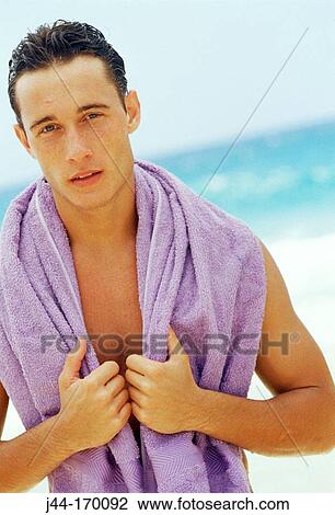 Young man with towel around neck at the beach View Large Photo Image Stock Image - Young man with towel around neck at the beach. Fotosearch