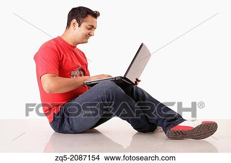 Picture - Young man working on his laptop computer, Pune, India.. Fotosearch