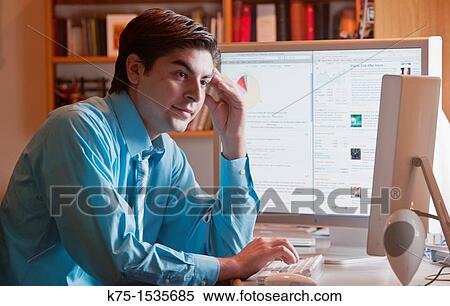 Stock Photography - Young man working with his computer. Fotosearch