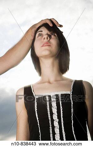 Young man's hand on top of a young woman's head. View Large Photo Image Stock Image - Young man's hand on top of a young woman's head.. Fotosearch
