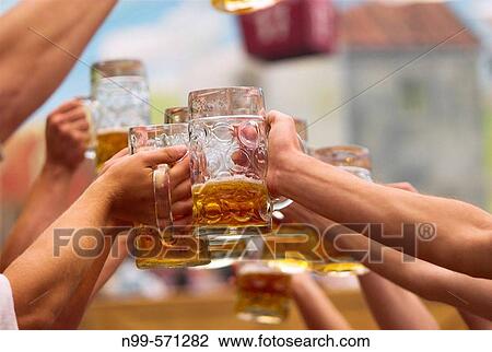 Young men with beer mugs at Oktoberfest beer tent. Munich, Bavaria, Germany View Large Photo Image Stock Image - Young men with beer mugs at Oktoberfest beer tent. Munich, Bavaria, Germany. Fotosearch