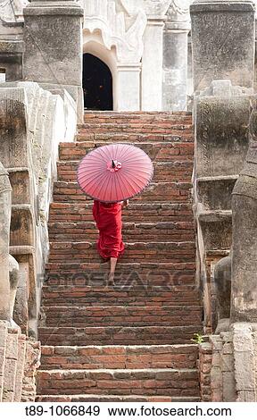 Young monk walking with umbrela View Large Photo Image Stock Photo - Young monk walking with umbrela. Fotosearch