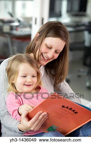 Young mother reading children book to his three year old daughter in the living room View Large Photo Image Stock Photo - Young mother reading children book to his three year old daughter in the living room. Fotosearch