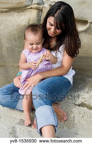 Young mother with infant at the beach View Large Photo Image Stock Image - Young mother with infant at the beach. Fotosearch