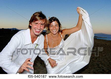 Young newly married couple running along a beach. View Large Photo Image Stock Photo - Young newly married couple running along a beach.. Fotosearch