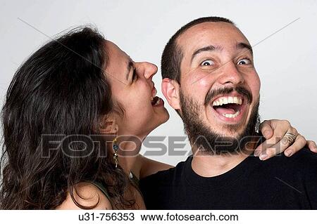 Stock Image - Young newlywed wife biting her husband's ear. Fotosearch