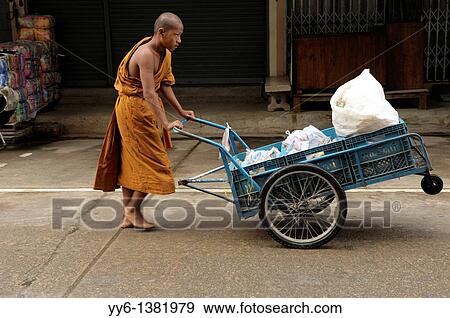 young novice monk pushing cart with food collecting on morning alms round, mae sot, northern thailand View Large Photo Image Stock Photo - young novice monk pushing cart with food collecting on morning alms round, mae sot, northern thailand. Fotosearch