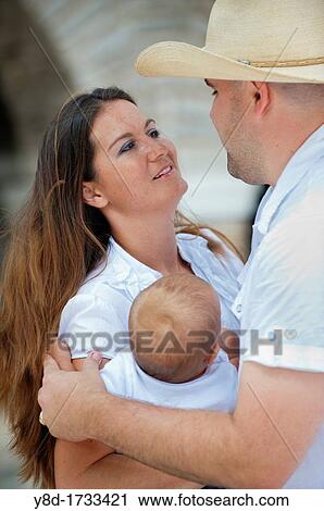 Stock Image - Young parents with their baby boy. Fotosearch
