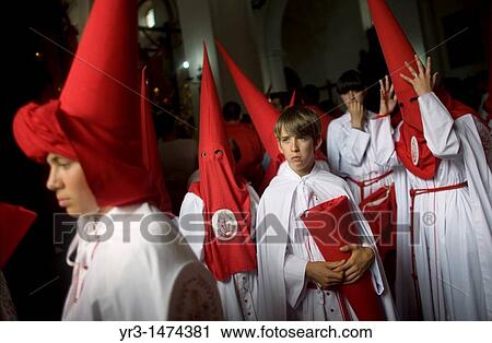 Stock Image - Young penitents stand inside a church waiting to start an Easter Holy Week procession in Carmona, Seville province, Ansalusia, Spain, May 19, 2001 The procession was canceled because it was raining. Fotosearch