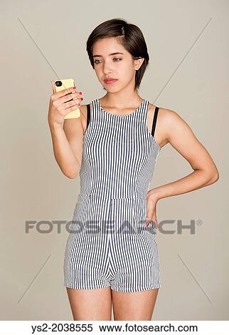 Stock Photography - Young pensive woman reading text message on her mobile.. Fotosearch