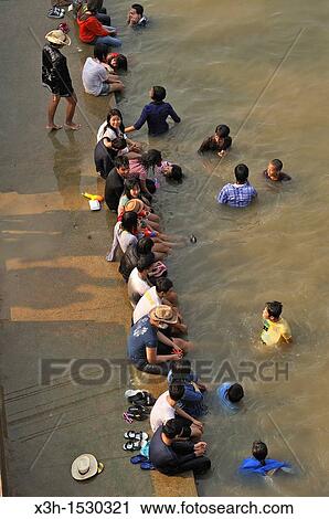 Stock Image - young people bathing into the Chao Praya river, Songkran festival, New Year's Day, Ayutthaya, Thailand, Asia. Fotosearch