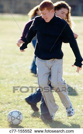 Young people playing football View Large Photo Image Stock Image - Young people playing football. Fotosearch