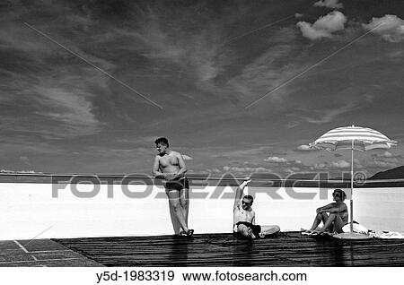 Young people resting at poolside, summertime View Large Photo Image Stock Photo - Young people resting at poolside, summertime. Fotosearch