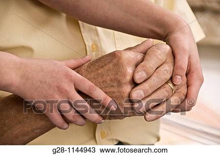 young person hands helping and comforting a senior man by holding his hands View Large Photo Image Stock Image - young person hands helping and comforting a senior man by holding his hands. Fotosearch