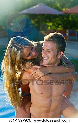 Young playful couple by the pool View Large Photo Image Stock Photograph - Young playful couple by the pool. Fotosearch