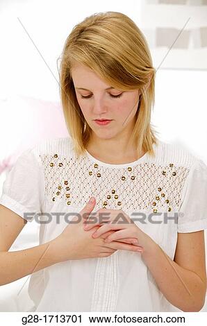 Young pretty blond woman scratching her itching hand at the base of her thumb View Large Photo Image Stock Image - Young pretty blond woman scratching her itching hand at the base of her thumb. Fotosearch