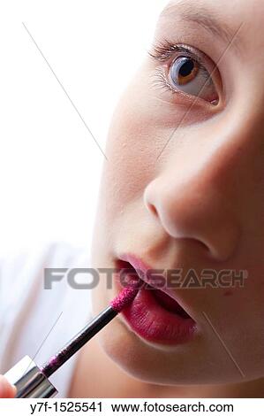 Young pretty girl making up with pink lipstick View Large Photo Image Stock Image - Young pretty girl making up with pink lipstick. Fotosearch