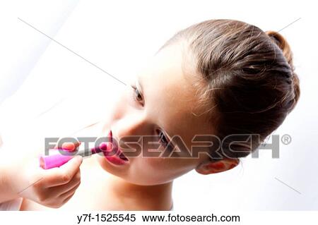 Young pretty girl making up with lipstick View Large Photo Image Stock Photography - Young pretty girl making up with lipstick. Fotosearch