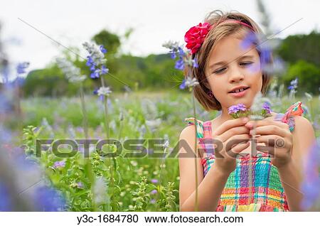 Stock Image - Young pretty girl of 8 years is picking wildflowers. Fotosearch
