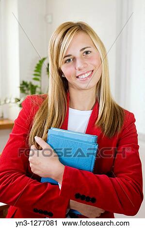 Young pretty student holding books View Large Photo Image Stock Image - Young pretty student holding books. Fotosearch