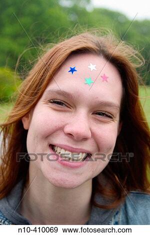 Young redhead woman at a park in Connecticut, USA, with colored paper stars pasted onto her forehead. View Large Photo Image Stock Photo - Young redhead woman at a park in Connecticut, USA, with colored paper stars pasted onto her forehead.. Fotosearch