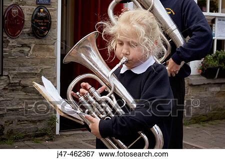 Young schoolgirl playing musical instrument in a street parade View Large Photo Image Stock Photo - Young schoolgirl playing musical instrument in a street parade. Fotosearch