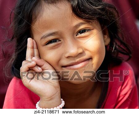 Stock Image - Young smiling Cambodian girl posing.. Fotosearch