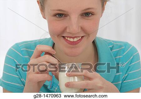 Young smiling woman eating a yogurt View Large Photo Image Stock Image - Young smiling woman eating a yogurt. Fotosearch